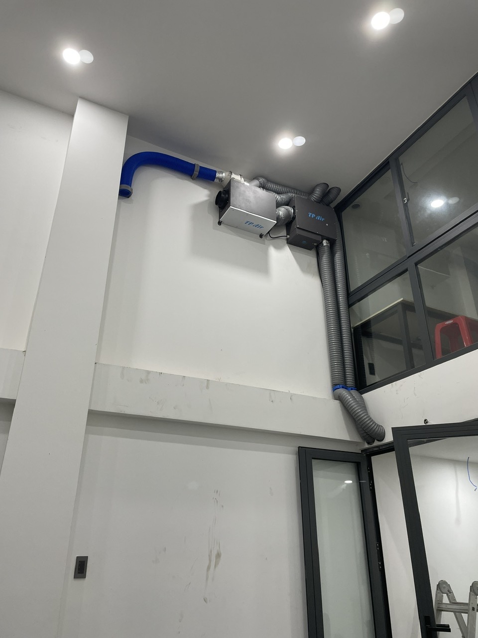 Máy cấp khí tươi TP AIR-N được gắn sát tường tại khu vực thông với sân trước văn phòng