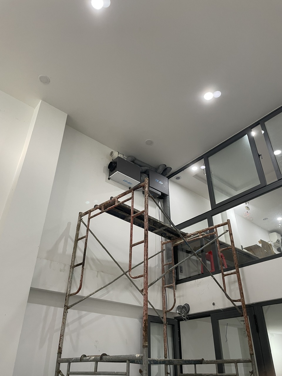Kỹ thuật viên đang tiến hành lắp đặt máy cấp khí tươi tại văn phòng tầng lửng Quận Tân Bình
